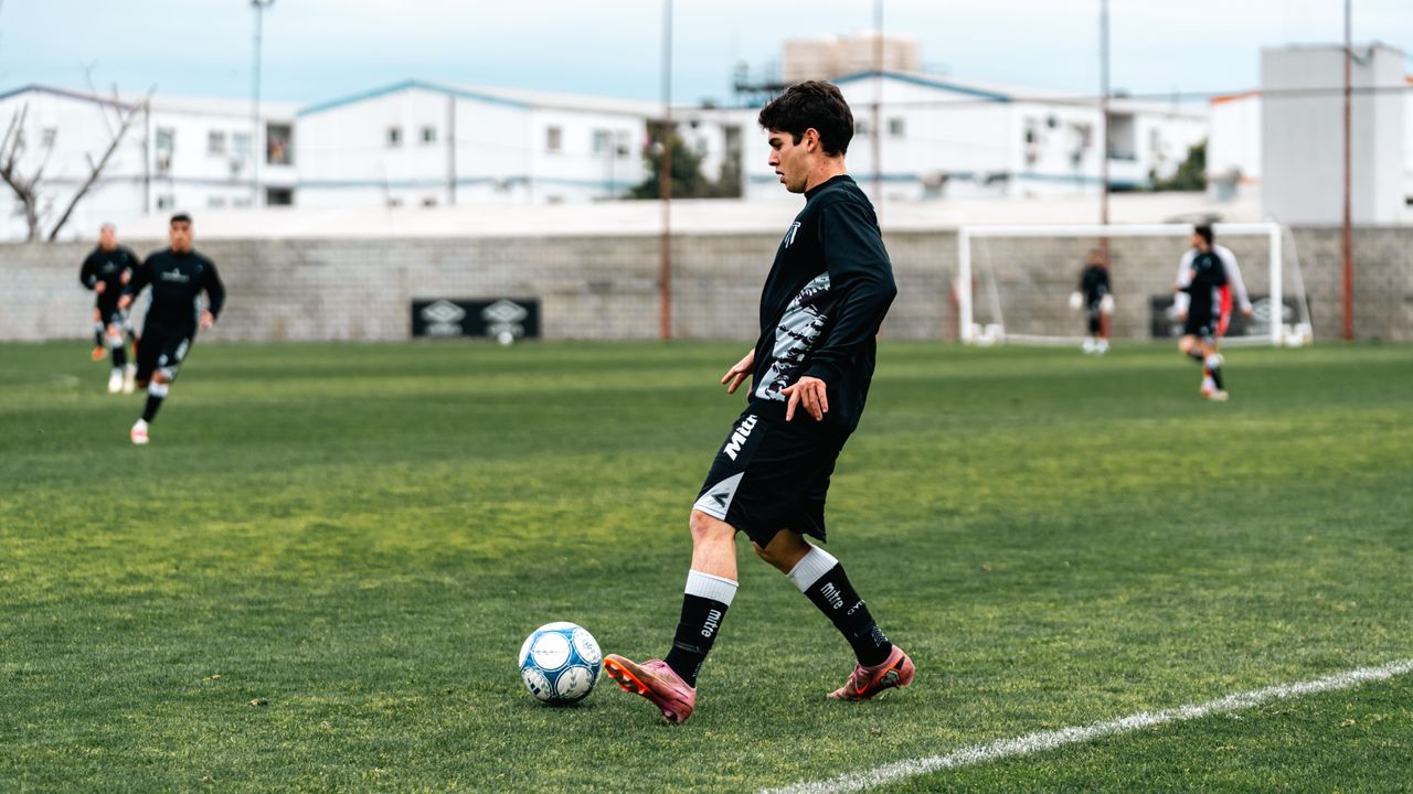 services-05 A young male soccer player in action on a grassy field during practice.