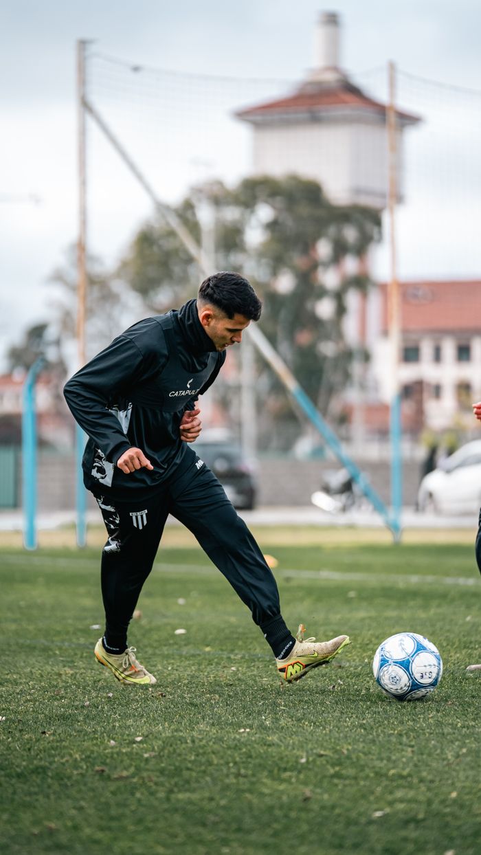 our-value Young adult male practicing soccer on an outdoor urban field, showcasing athletic skills.